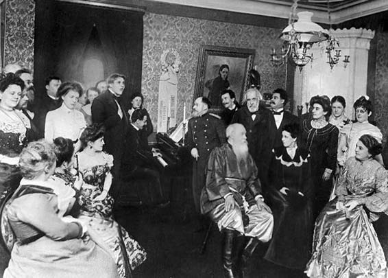 Vladimir Stasov (assis au centre), Fiodor Chaliapine (debour derrière le pianiste), César Cui (acoudé au piano), Nikolai Rimsky-Korsakov (à gauce dans le fond), 1901